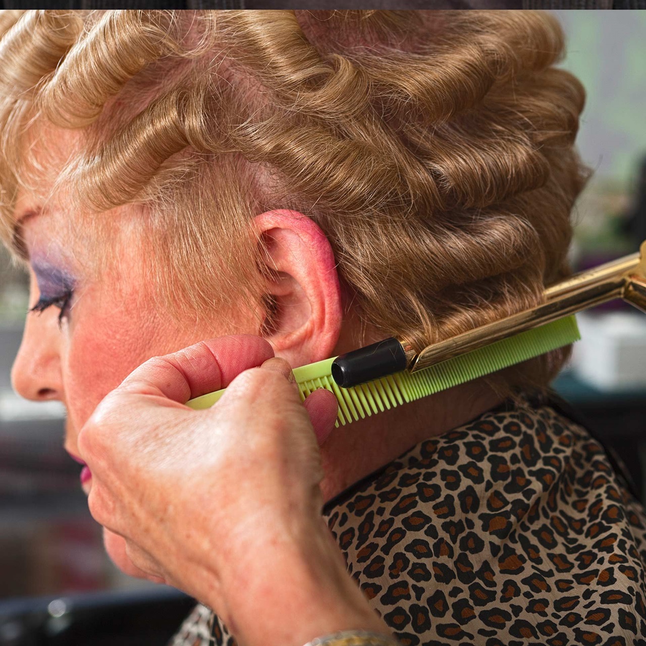 Die Haare einer Dame werden mit dem Lockenstab gelockt